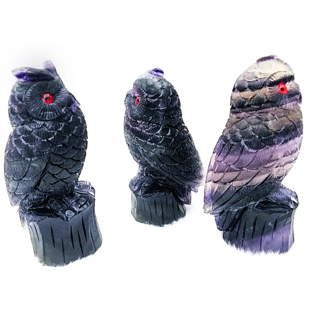 Hand carved purple fluorite owl statue approximately 4 inches tall on a flat surface