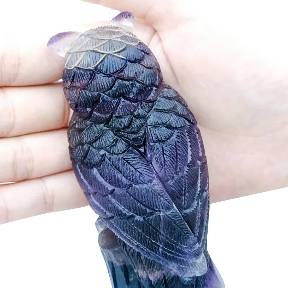 Hand carved purple fluorite owl statue approximately 4 inches tall on a flat surface