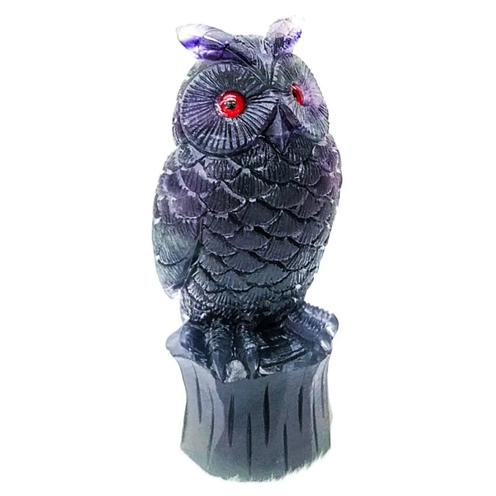 Hand carved purple fluorite owl statue approximately 4 inches tall on a flat surface