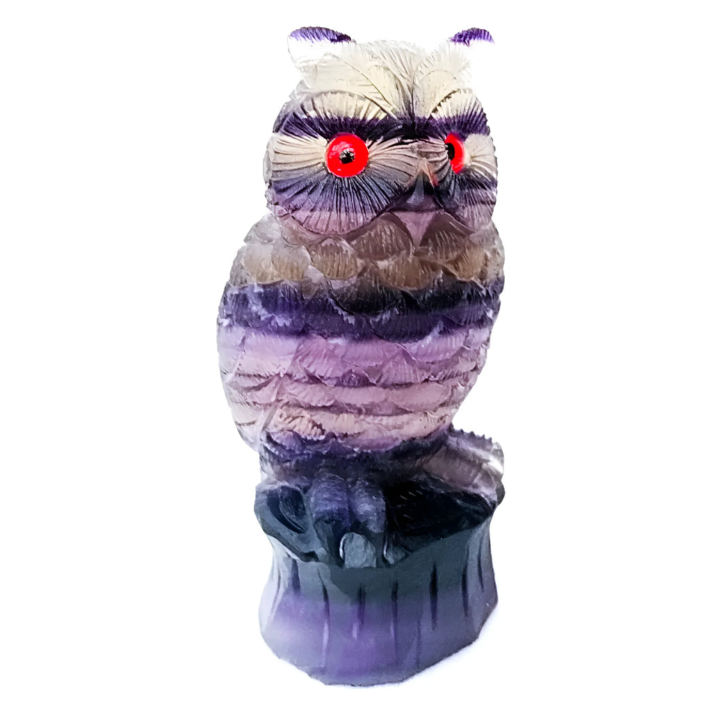 Hand carved purple fluorite owl statue approximately 4 inches tall on a flat surface