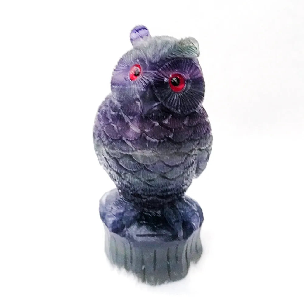 Hand carved purple fluorite owl statue approximately 4 inches tall on a flat surface