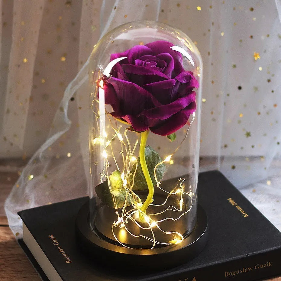 LED illuminated glass bouquet with pink silk roses and warm white lighting on wooden table