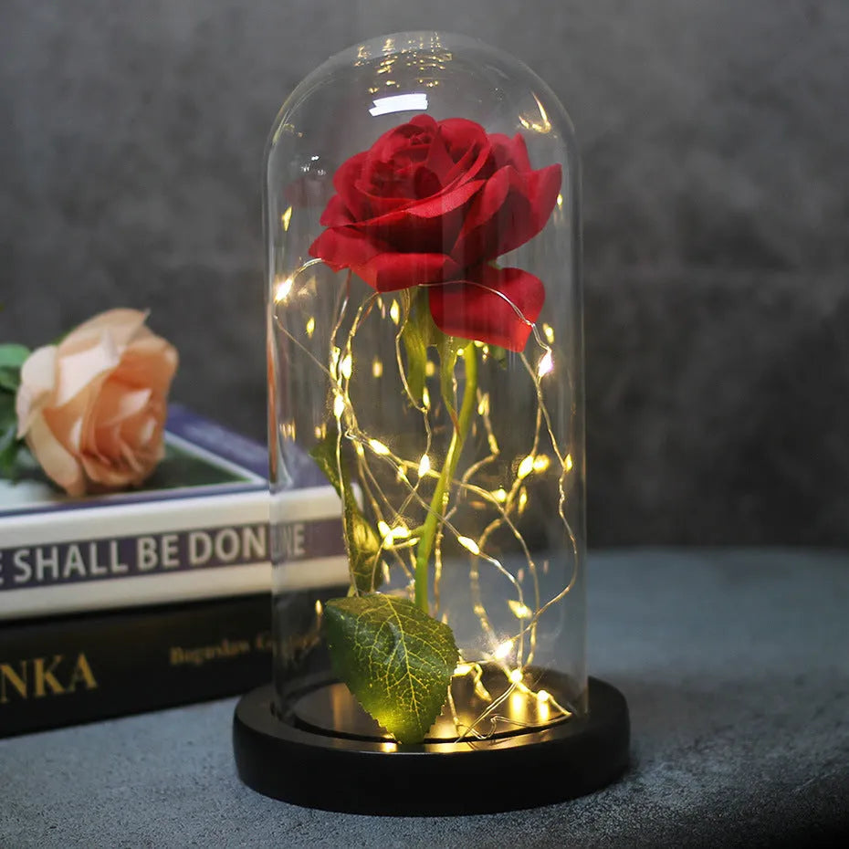 LED illuminated glass bouquet with pink silk roses and warm white lighting on wooden table