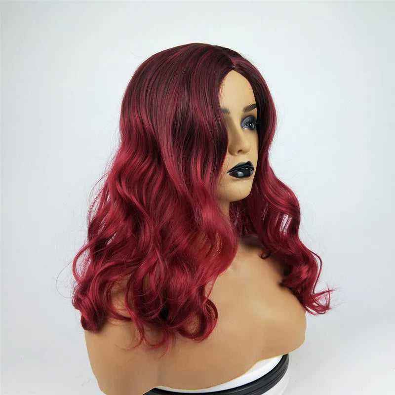 Burgundy long curly wig with gradient colour and centre bangs on a wig stand