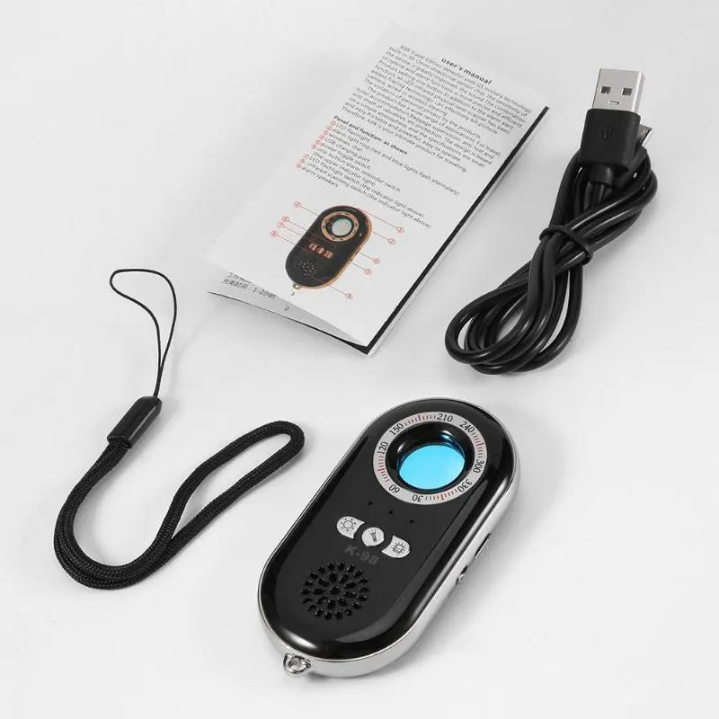 Compact black wireless signal detector with vibration alarm for travel security, shown next to a ruler for scale.