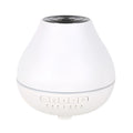 White round Bluetooth humidifier and aroma diffuser with LED night light on wooden surface