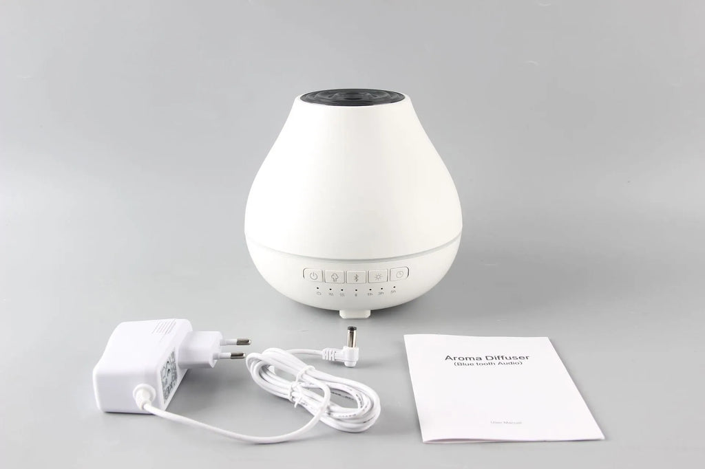 White round Bluetooth humidifier and aroma diffuser with LED night light on wooden surface