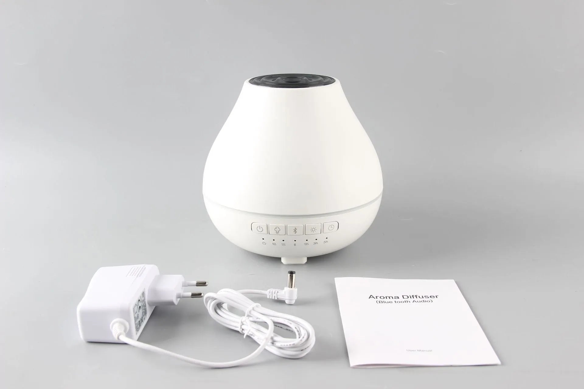 White round Bluetooth humidifier and aroma diffuser with LED night light on wooden surface