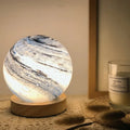 Nordic style USB table lamp with a glass shade on a wooden bedside table.