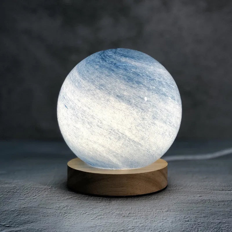 Nordic style USB-powered bedside table lamp with a coloured glass shade on a wooden table.