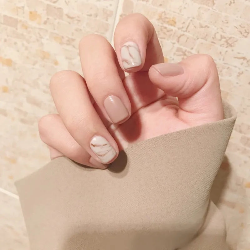 24 light khaki smudge false nails with glue in almond shape on white background
