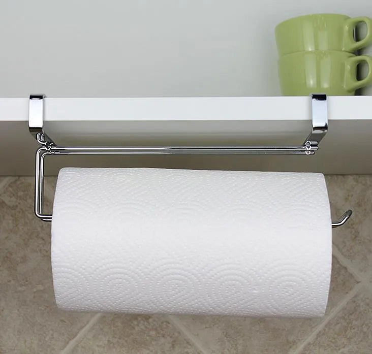 Silver stainless steel paper towel rack hanging on a wooden cabinet door.