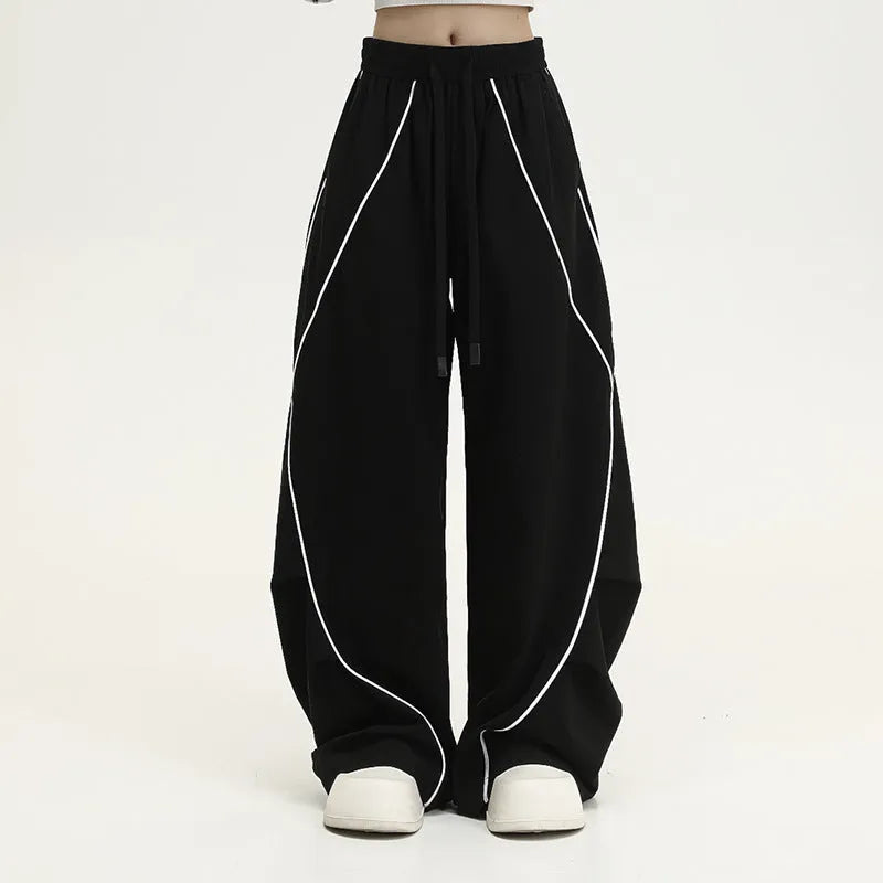 Black pleated wide-leg trousers with striped pattern showing mid-waist design and loose fit