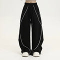 Black pleated wide-leg trousers with striped pattern showing mid-waist design and loose fit