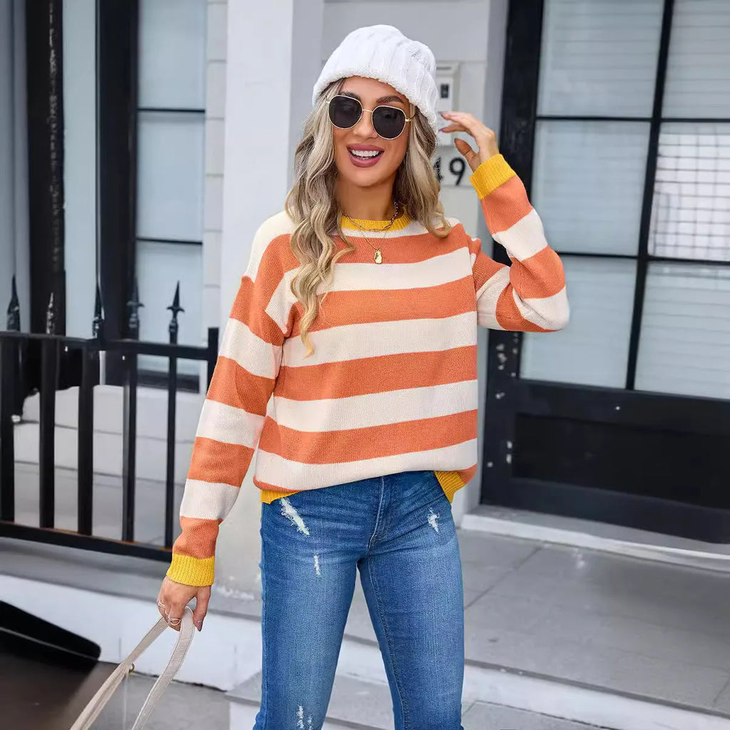 Women's loose fit long sleeve acrylic sweater in blue with a striped pattern, showing round neck.