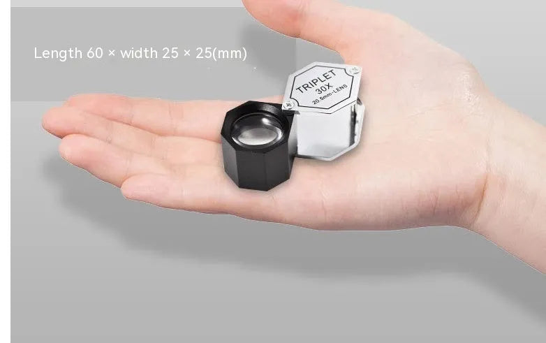 Handheld portable magnifying glass with metal body for jewellery and coin identification.