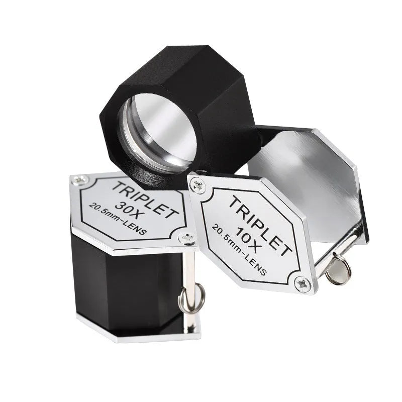 Handheld portable magnifying glass with metal body for jewellery and coin identification.