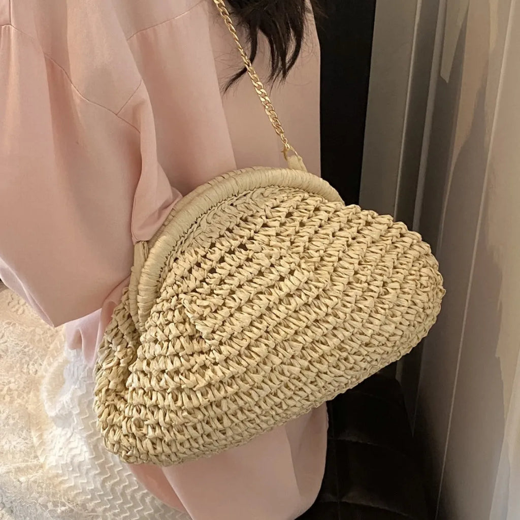 Khaki shell-shaped straw shoulder bag for women with chain detail and zippered pocket.