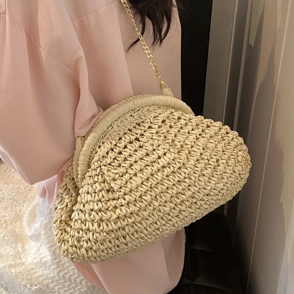 Khaki shell-shaped straw shoulder bag for women with chain detail and zippered pocket.