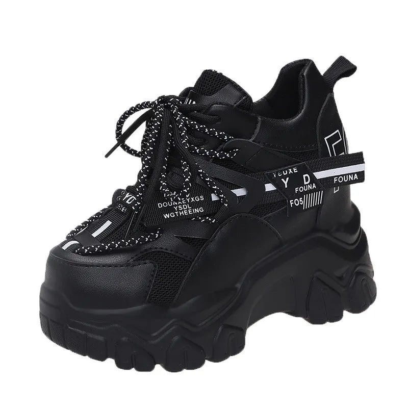 White and black women's low-top platform sports shoes with cross-strap and mesh design on a rubber sole.