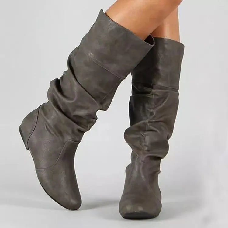 Women's black flat-heel slip-on long boots with a high shaft and round toe.