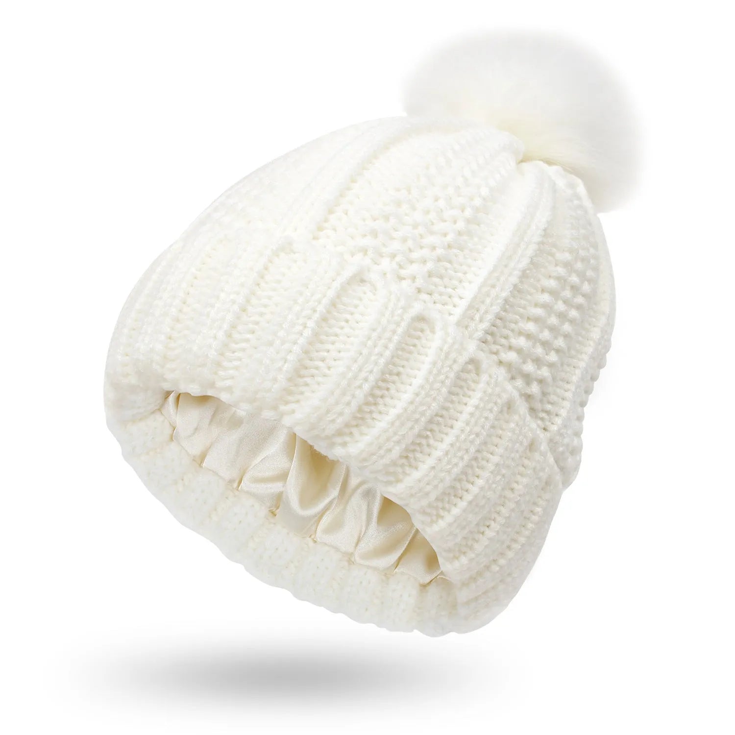 Woman wearing a black knitted beanie with a grey faux fur pom pom, showing the satin lining.