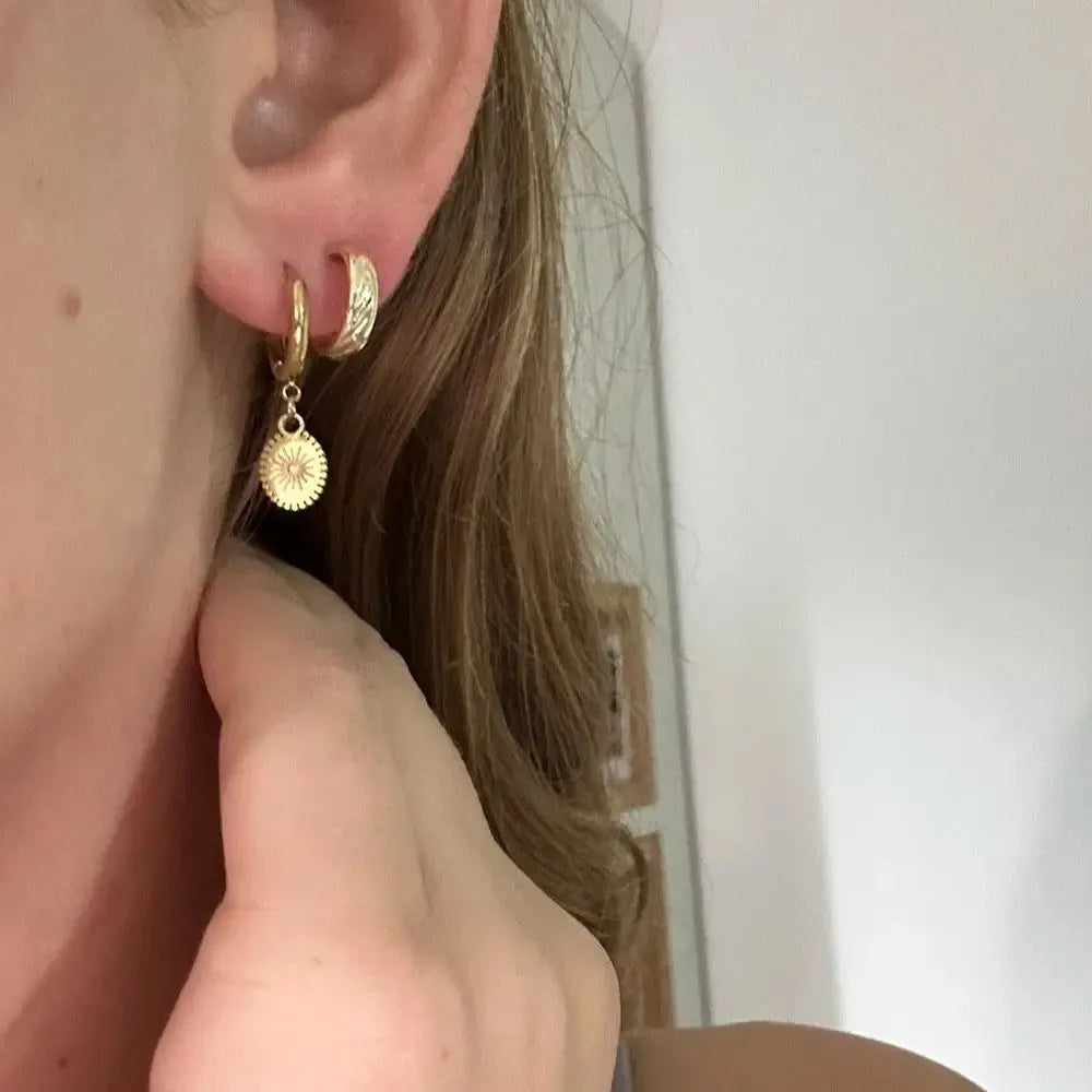 A pair of stainless steel geometric ear button earrings with an ellipse detail, style XY-EH005.