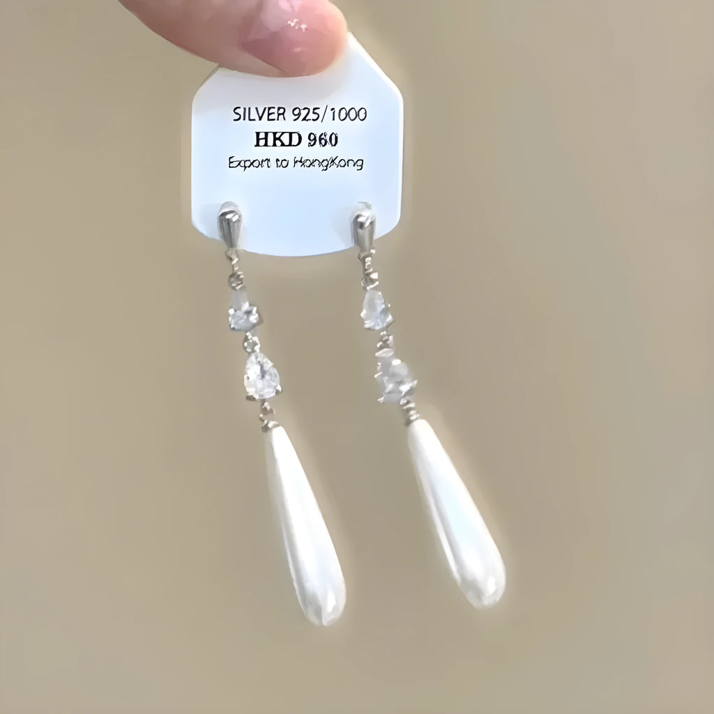 Geometric alloy ear clip with a heart rhinestone and dangling tassel, showing both stud and clip-on back options.