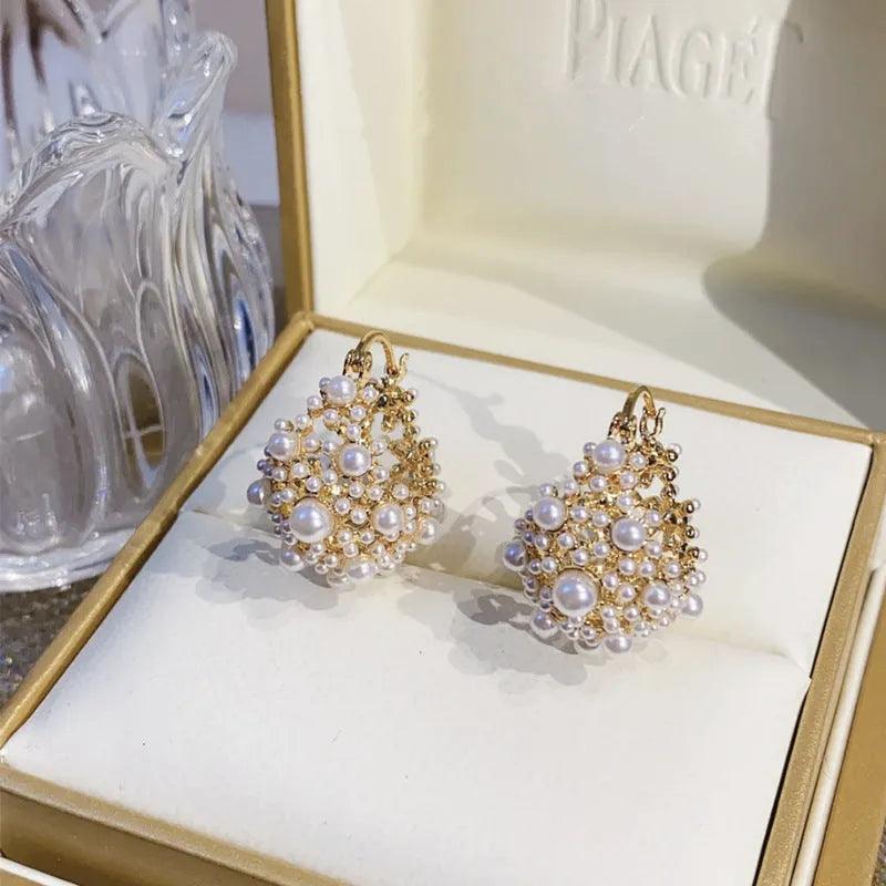 Gold-coloured copper flower basket earrings with white pearl inlay and small rice-shaped bead details.