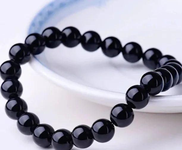 Black agate stretch bracelet with 8mm geometric beads on a black elastic cord.