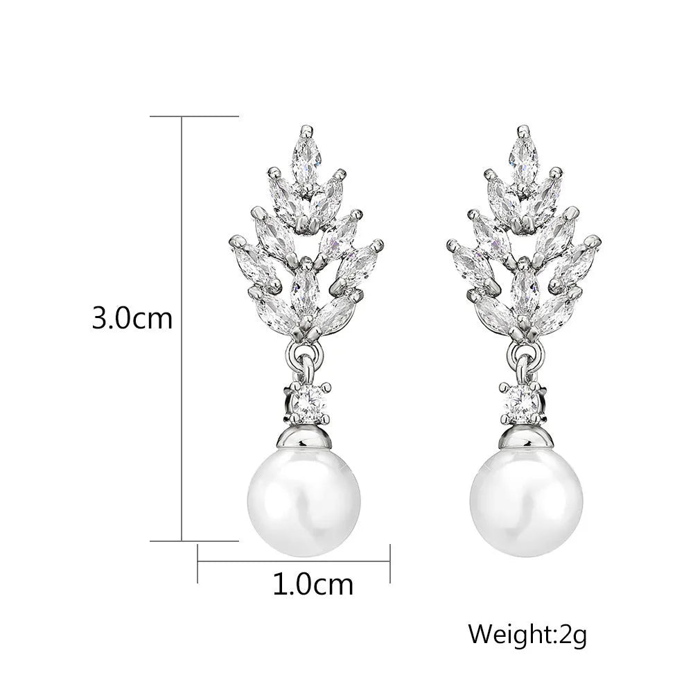 Geometric flower shaped earrings with micro inlaid zircon stones and pearl details on gold plating.