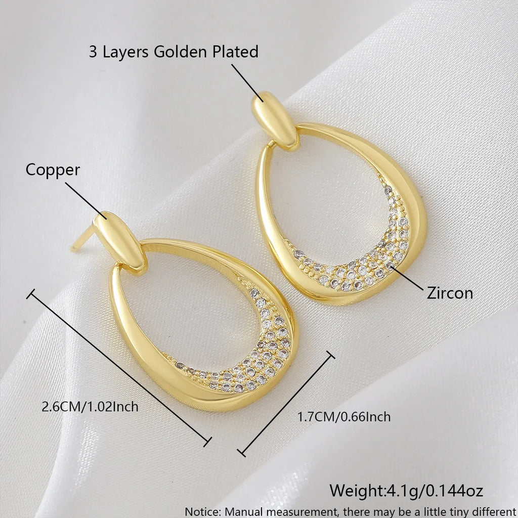 Yellow gold geometric drop earrings with zircon detailing measuring 2.6 by 1.7 centimetres
