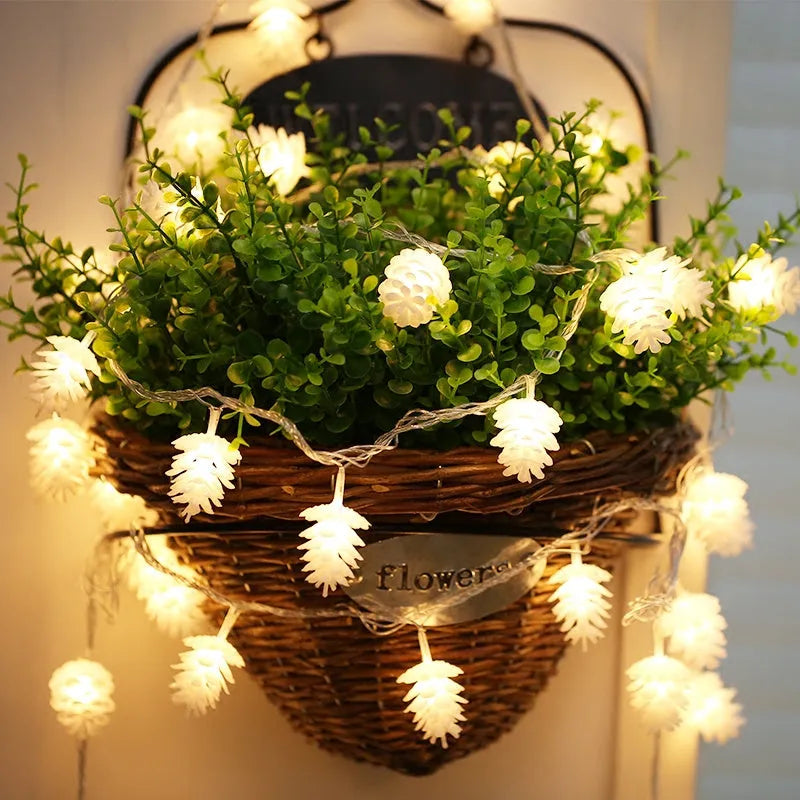 Warm white LED pine cone light string on a dark background, showing plastic shell details.