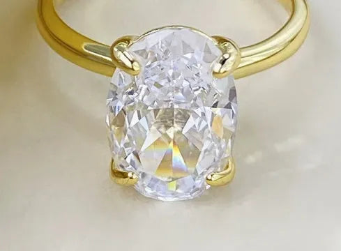 Oval gemstone ring in four-claw setting, available in gold and silver colours