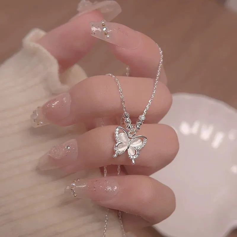 A silver necklace with a butterfly pendant on a cross chain, showing adjustable length.