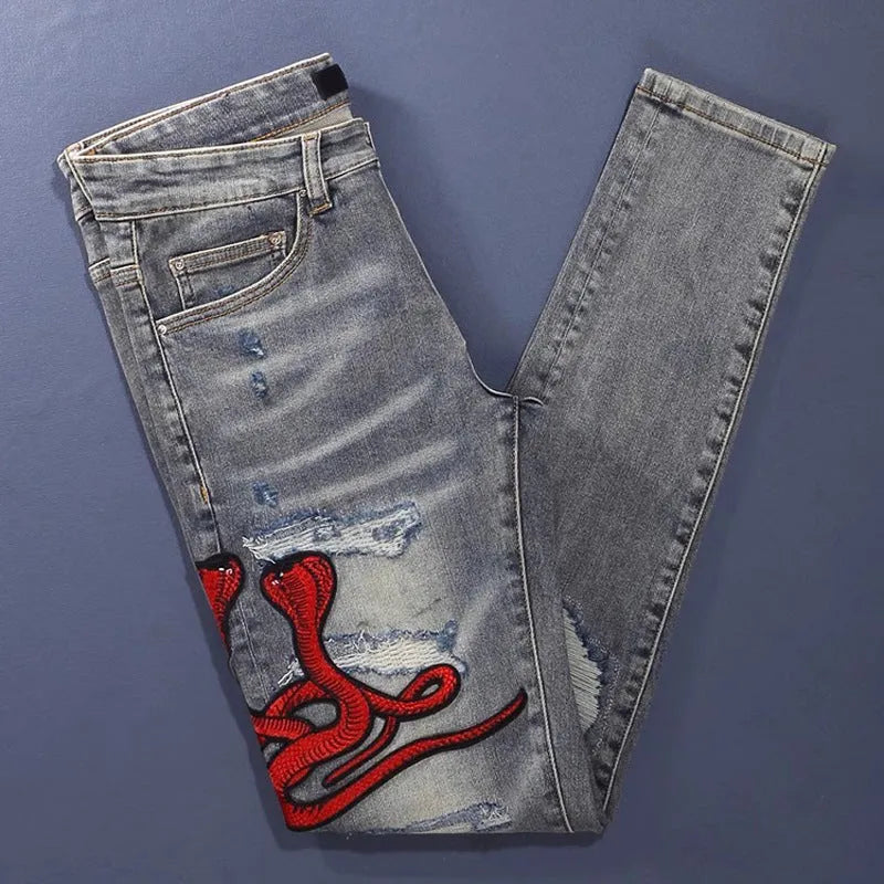 Washed-out old colour slim fit jeans with distressed patches and embroidery detail