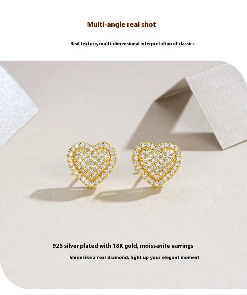 A pair of simple S925 sterling silver stud earrings with a gold-coloured finish and a heart-shaped moissanite stone.