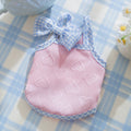 Small dog wearing elastic vest with bow suspenders and heart texture