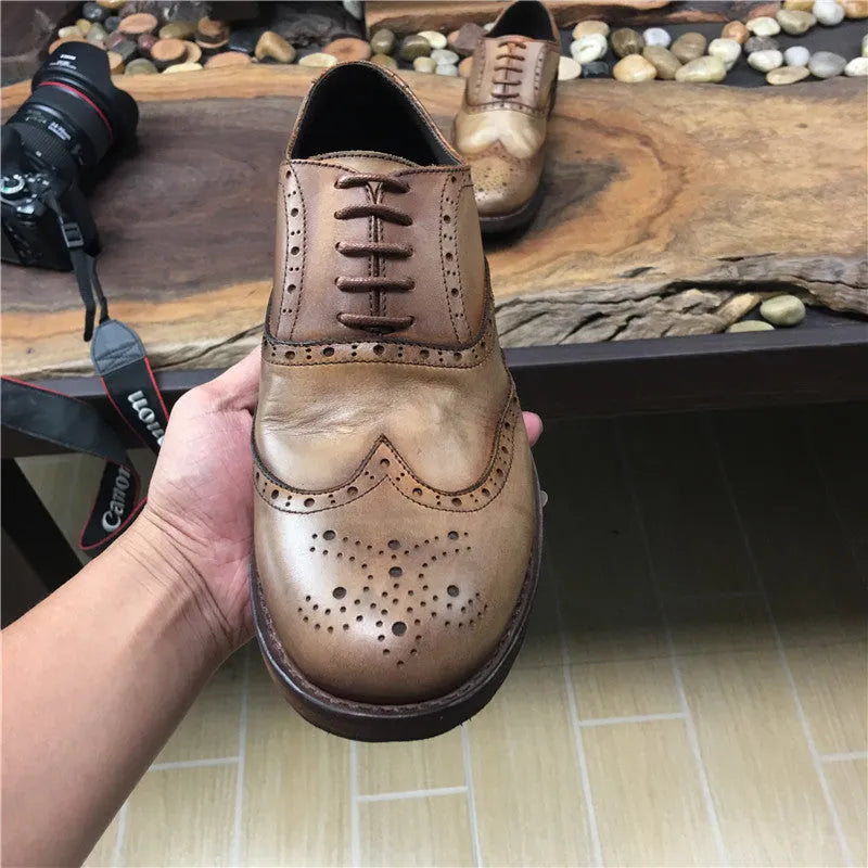 Men's light brown vintage leather lace-up shoes with carved detailing and a round toe.