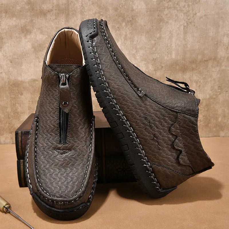 Men's black slip-on leather loafers with a round toe and flat rubber sole, shown on a foot.