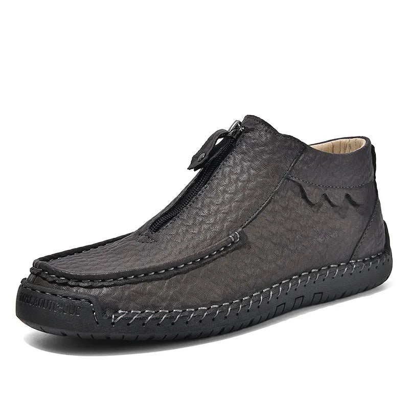 Men's black slip-on leather loafers with a round toe and flat rubber sole, shown on a foot.