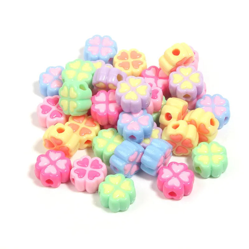 Assortment of 15mm frosted acrylic four-leaf clover craft beads in light colours.