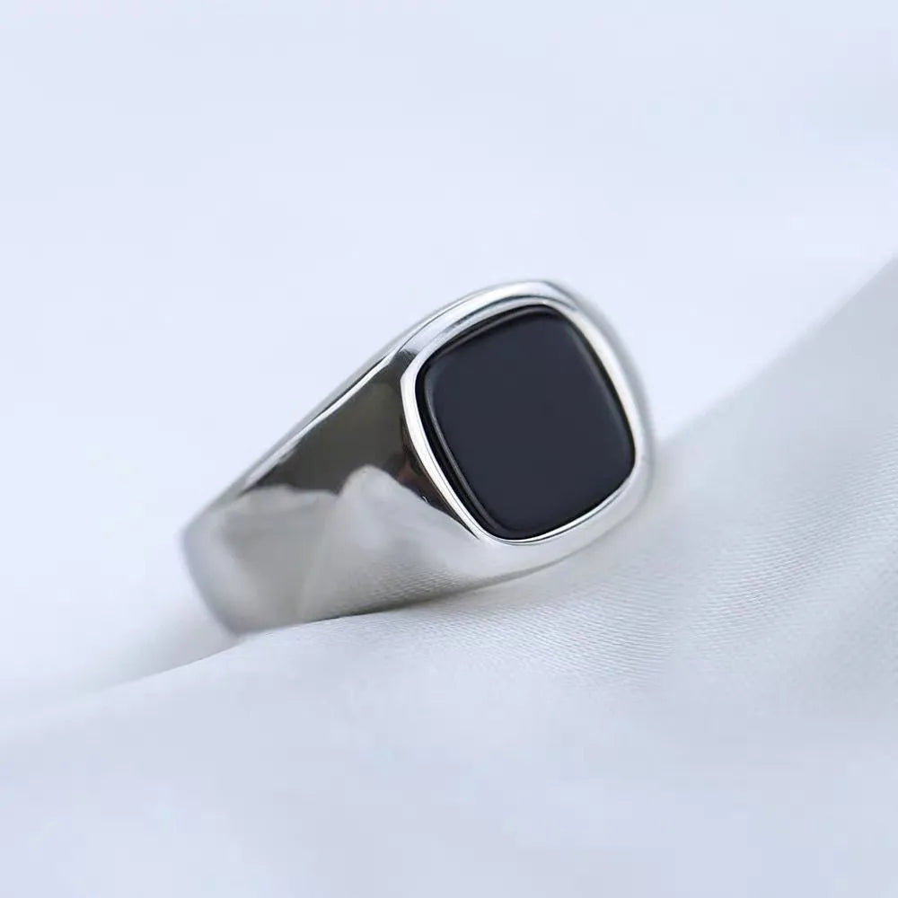 Men's titanium steel hexagonal ring with glossy black epoxy inlay and polished finish on white background