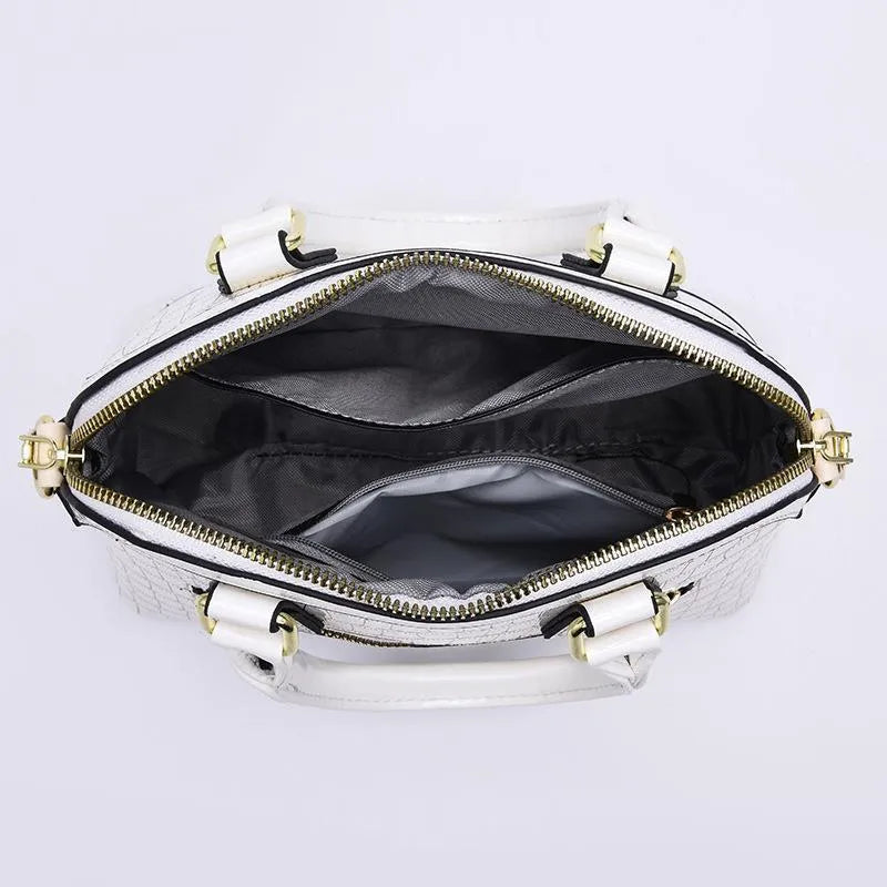 Women's solid colour shell shape PU handbag with metal hardware, zipper closure, and soft top handle