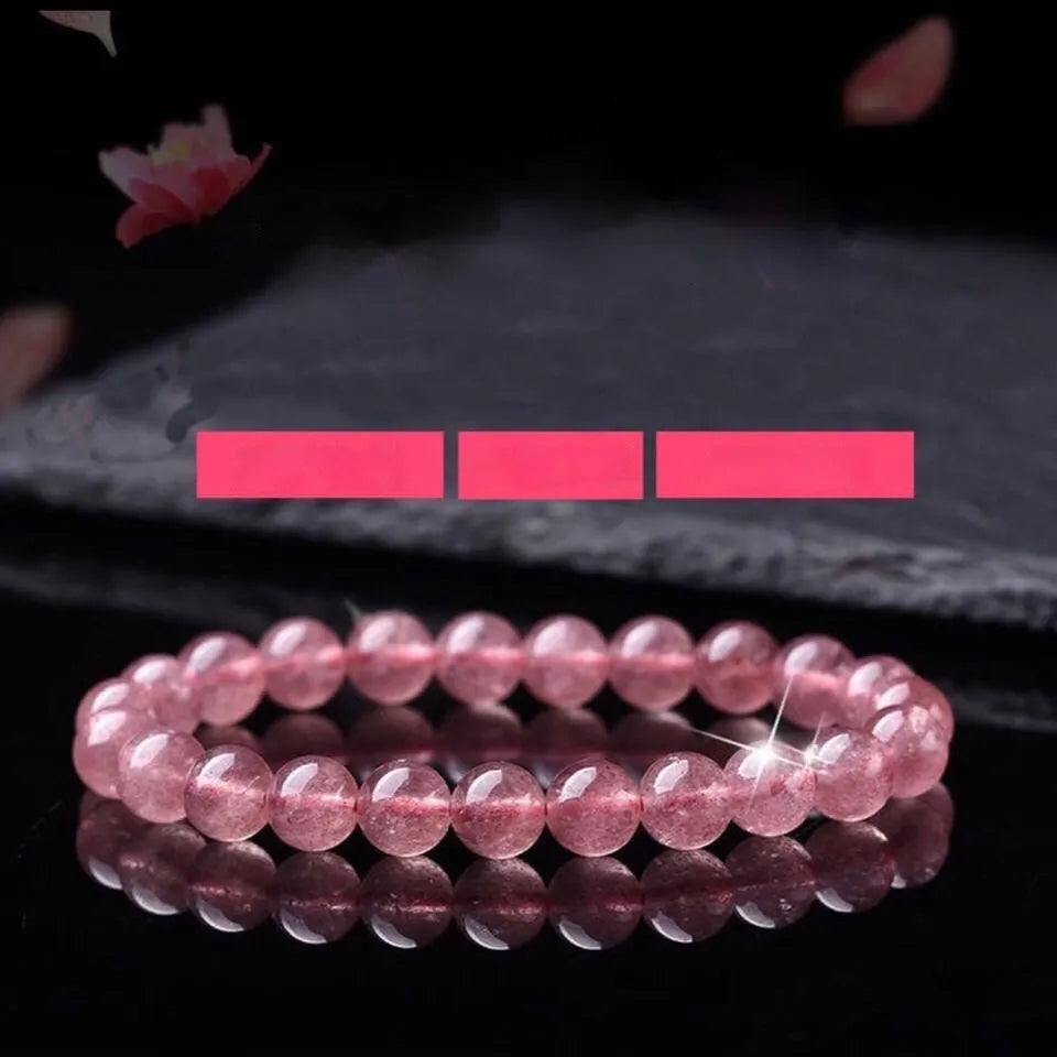 Close-up of a women's bracelet with polished strawberry quartz crystal beads in natural tones.