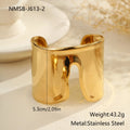 Wide geometric wave bracelet in gold-plated stainless steel on a woman's wrist.