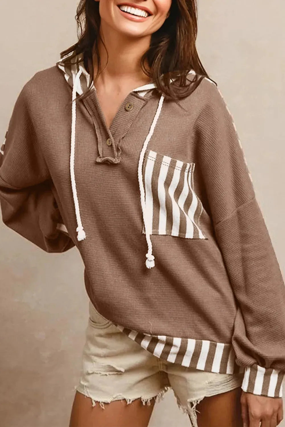 Straw yellow long sleeve hoodie with waffle texture, striped patchwork, button neck, and drawstring hood.