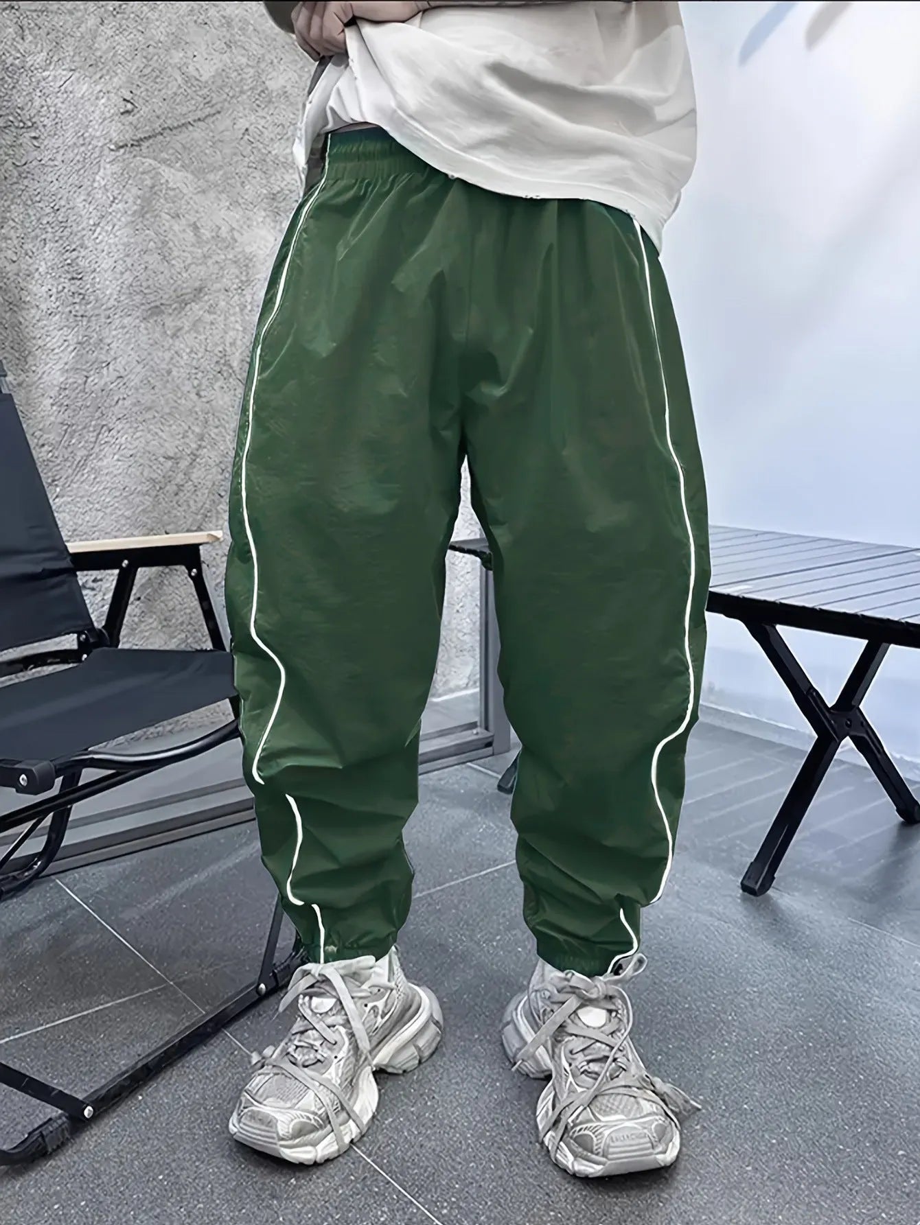 Man wearing loose-fit, cropped-length bamboo fibre sports trousers in a neutral colour.