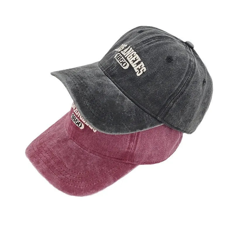Adjustable peak cap with embroidered letters in distressed retro style, showing conical crown and 7cm brim