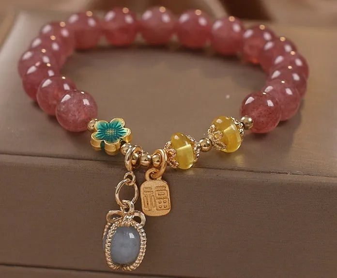 Natural strawberry quartz beaded bracelet red alloy with rhinestone details on white background